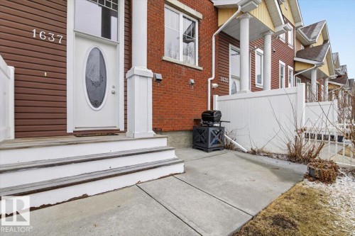 The property features a white oval-lite entry door with decorative glass, complemented by a white column at the entrance - 1637 Towne Centre Boulevard, Edmonton, AB - Outdoor