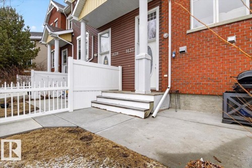 The property features a concrete walkway leading to the entrance, complemented by a white picket fence and privacy fencing - 1637 Towne Centre Boulevard, Edmonton, AB - Outdoor