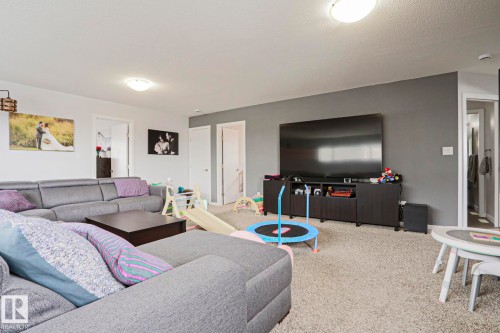This room features light-colored carpet flooring and a neutral color palette with white and gray walls - 18 Enchanted Way, St. Albert, AB 