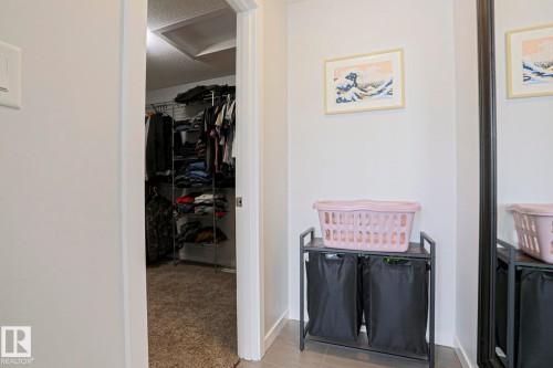 The property includes a walk-in closet with carpet flooring and organized shelving - 18 Enchanted Way, St. Albert, AB 