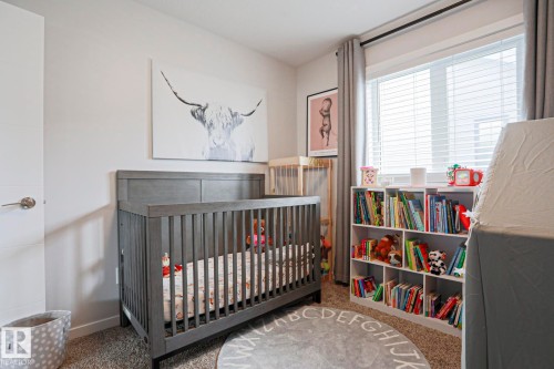The room features carpeted flooring, a window with blinds, and light-colored walls - 18 Enchanted Way, St. Albert, AB 