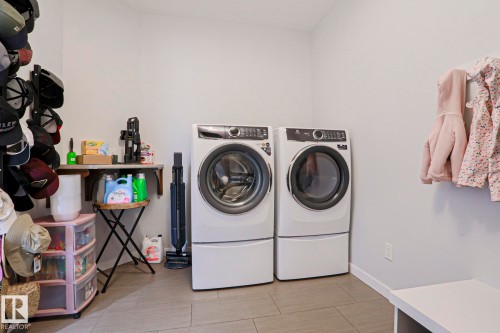 Laundry area featuring a side-by-side washer and dryer, tile flooring, and light-colored walls - 18 Enchanted Way, St. Albert, AB 