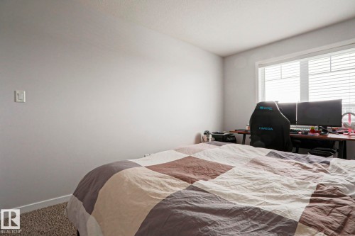 This room features light gray walls, a window with horizontal blinds, and a textured carpet - 18 Enchanted Way, St. Albert, AB 