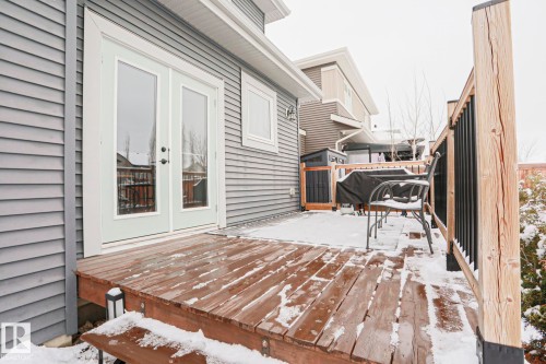 The property features a wooden deck with a wooden railing and black balusters - 18 Enchanted Way, St. Albert, AB 