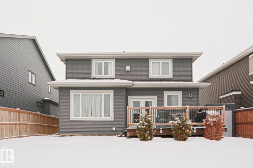 The property features gray horizontal siding, white trim, and a rear deck with wood railings - 18 Enchanted Way, St. Albert, AB 