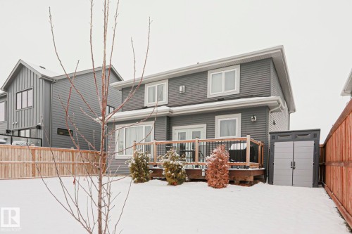 The property features a two-story exterior with horizontal siding, multiple windows, and a wooden deck - 18 Enchanted Way, St. Albert, AB 