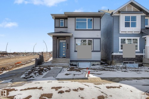 The property features a contemporary exterior with light grey siding and dark grey trim, complemented by a brick-clad entry - 21203 25 Avenue, Edmonton, AB - Outdoor With Facade