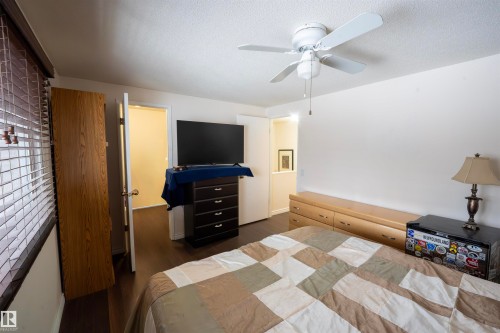 This room features hardwood flooring, white walls, and a ceiling fan - 1728 37 Street, Edmonton, AB - Indoor Photo Showing Bedroom
