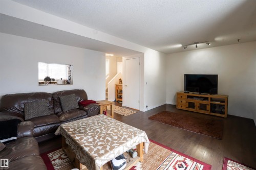 Living area featuring dark flooring, white walls, and track lighting - 1728 37 Street, Edmonton, AB - Indoor Photo Showing Living Room