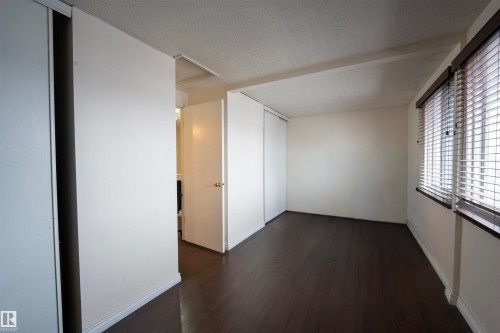 This room features dark-toned flooring, white walls, and a window with blinds - 1728 37 Street, Edmonton, AB - Indoor Photo Showing Other Room