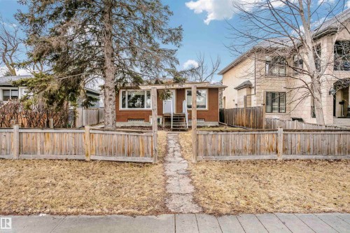 The property features a front yard with a wooden fence and a stone path leading to the entrance - 6524 112 Street, Edmonton, AB - Outdoor
