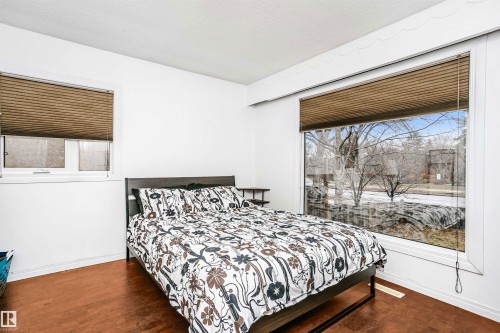 This room features dark wood flooring and white walls, creating a bright and inviting atmosphere - 6524 112 Street, Edmonton, AB - Indoor Photo Showing Bedroom
