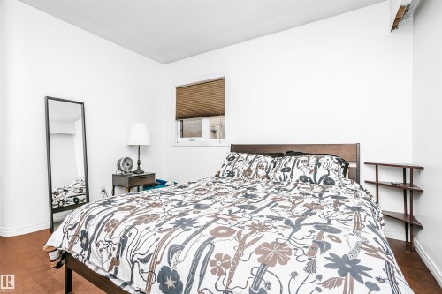 Bedroom featuring a window with blinds, light-toned walls, and wood flooring - 6524 112 Street, Edmonton, AB - Indoor Photo Showing Bedroom