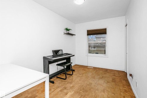 This space features light-colored walls and cork flooring, with a window providing natural light - 6524 112 Street, Edmonton, AB - Indoor Photo Showing Other Room