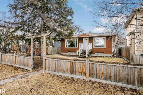 The property features a red brick exterior, a front entry with white steps and railing, and large windows - 6524 112 Street, Edmonton, AB - Outdoor
