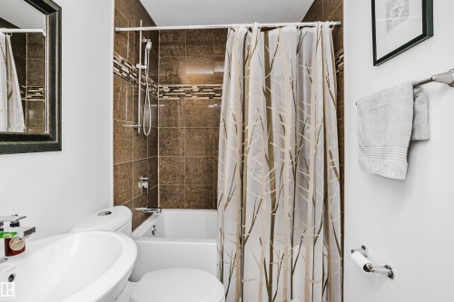 Bathroom featuring a tiled shower and bathtub combination with a decorative mosaic accent band - 6524 112 Street, Edmonton, AB - Indoor Photo Showing Bathroom