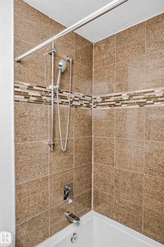 The bathroom features a shower/tub combination with brown tiled walls and a decorative mosaic accent strip - 6524 112 Street, Edmonton, AB - Indoor Photo Showing Bathroom