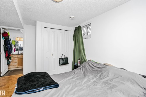 This room features a window with blinds, bi-fold closet doors, and light-colored walls - 6524 112 Street, Edmonton, AB - Indoor Photo Showing Bedroom