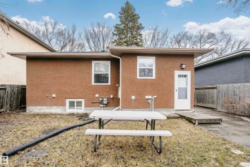 The property features a stucco exterior with a white door, framed by a wooden fence - 6524 112 Street, Edmonton, AB - Outdoor With Exterior
