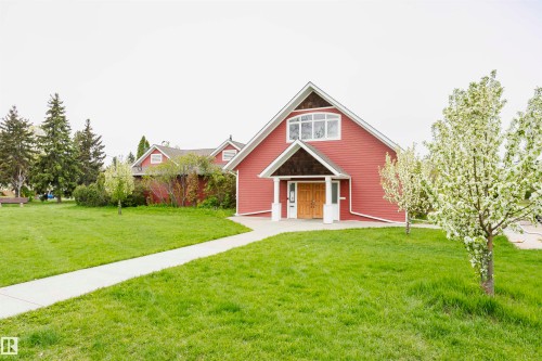 The property features a red facade with white trim, a gabled roof, and light-colored wooden double doors - 6524 112 Street, Edmonton, AB - Outdoor