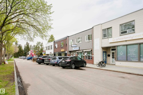 The property features a storefront with a white paneled facade and a large display window - 6524 112 Street, Edmonton, AB - Outdoor