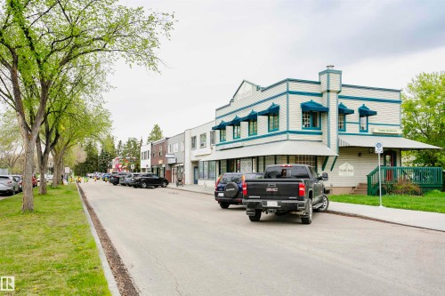The property features a distinctive facade with white siding and teal trim, complemented by matching awnings - 6524 112 Street, Edmonton, AB - Outdoor