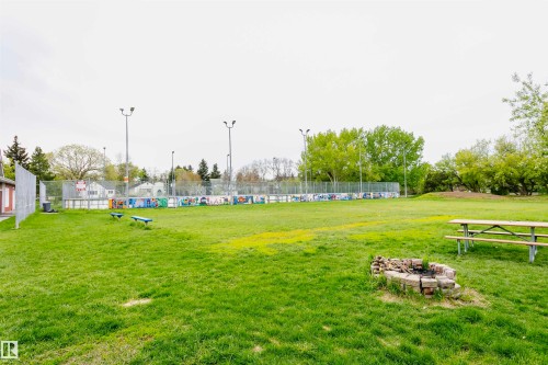 Spacious green area featuring a picnic table and a brick fire pit, perfect for outdoor enjoyment - 6524 112 Street, Edmonton, AB - Outdoor