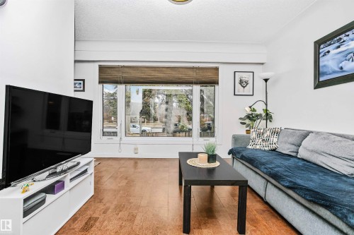 Living area with hardwood flooring, large windows, and white walls - 6524 112 Street, Edmonton, AB - Indoor Photo Showing Living Room