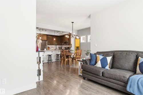 The property features an open-concept layout with light wood flooring throughout - 678 Secord Boulevard, Edmonton, AB - Indoor Photo Showing Living Room