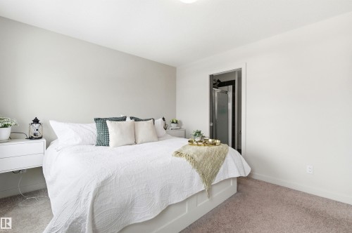 This bedroom features light-colored walls and plush carpeting, creating a serene ambiance - 678 Secord Boulevard, Edmonton, AB - Indoor Photo Showing Bedroom