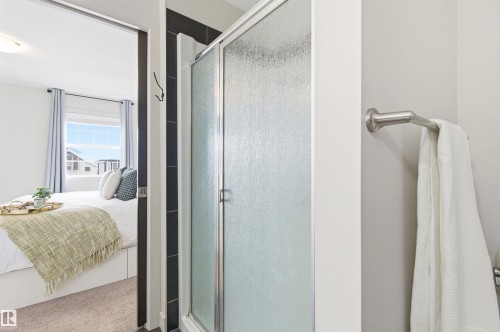 The bathroom features a shower with a frosted glass door and a towel rail - 678 Secord Boulevard, Edmonton, AB - Indoor Photo Showing Bathroom