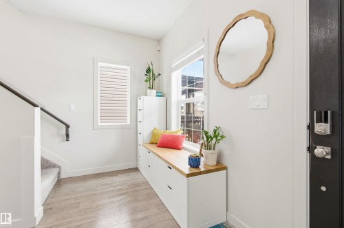 Entryway featuring light wood-style flooring, a staircase with carpeting, and a built-in bench with storage - 678 Secord Boulevard, Edmonton, AB - Indoor Photo Showing Other Room