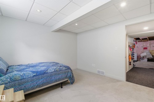 This room features light-colored walls and carpeting, with a drop ceiling incorporating recessed lighting - 678 Secord Boulevard, Edmonton, AB - Indoor Photo Showing Bedroom
