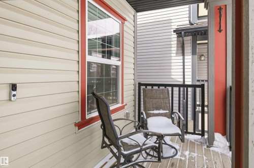 The property features an outdoor patio with wooden decking and a black metal railing - 678 Secord Boulevard, Edmonton, AB - Outdoor With Exterior