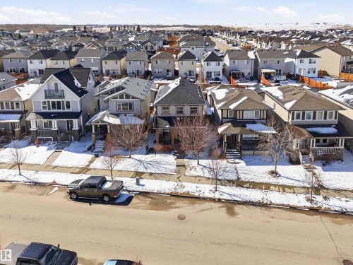 The property features a two-story design with a front porch, a gabled roof, and a paved walkway leading to the entrance - 678 Secord Boulevard, Edmonton, AB - Outdoor With Facade