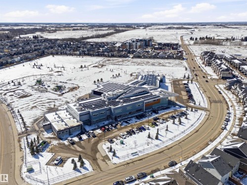 Aerial view of the neighborhood showcasing a large building with solar panels on the roof, surrounded by parking areas and roads - 678 Secord Boulevard, Edmonton, AB - Outdoor With View