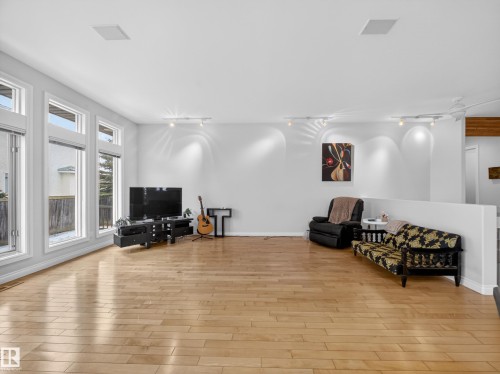 The property features light hardwood floors, large windows that allow for ample natural light, and clean white walls - 569 Butterworth Way, Edmonton, AB - Indoor