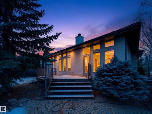 The property features an exterior with large windows, a deck with stairs, and a paved patio area - 569 Butterworth Way, Edmonton, AB - Outdoor