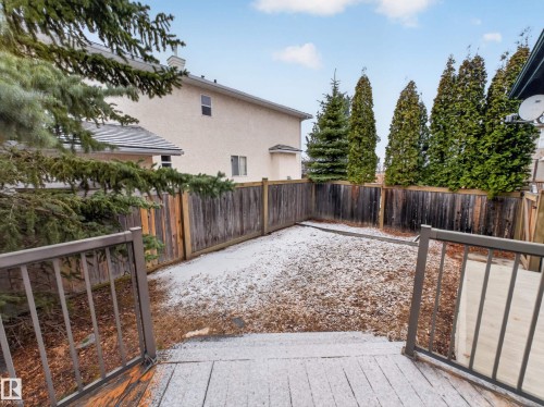 The property features a private yard with a wooden fence and mature evergreen trees - 569 Butterworth Way, Edmonton, AB - Outdoor