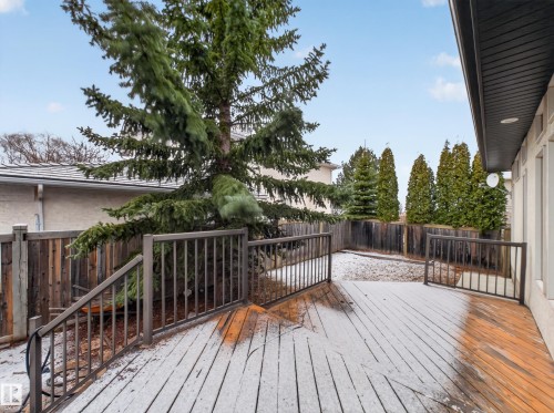 The property features a spacious wooden deck with a dark metal railing, offering direct access to the fenced yard - 569 Butterworth Way, Edmonton, AB - Outdoor With Deck Patio Veranda With Exterior