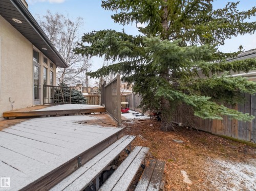 The property features a wooden deck with railing, accessible via glass panel doors - 569 Butterworth Way, Edmonton, AB - Outdoor