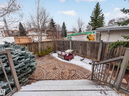 The property features an outdoor patio area with a circular paver design, surrounded by a wooden fence - 569 Butterworth Way, Edmonton, AB - Outdoor