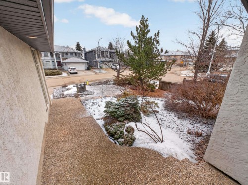 Exterior view of the property's entrance, featuring a sloped concrete walkway and a landscaped area with evergreens and various plantings - 569 Butterworth Way, Edmonton, AB - Outdoor
