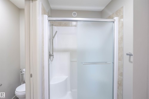 Bathroom featuring a dark vanity with two integrated sinks, a large mirror, and overhead lighting - 1426 25 Avenue, Edmonton, AB - Indoor Photo Showing Bathroom