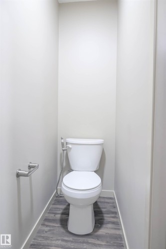 Bathroom featuring a shower with a sliding frosted glass door, a showerhead with a handheld sprayer, and tiled walls - 1426 25 Avenue, Edmonton, AB - Indoor Photo Showing Bathroom
