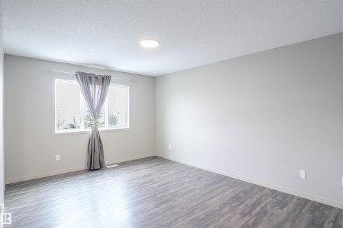 Spacious room featuring light gray walls, recessed lighting, and wood-look flooring - 1426 25 Avenue, Edmonton, AB - Indoor Photo Showing Other Room