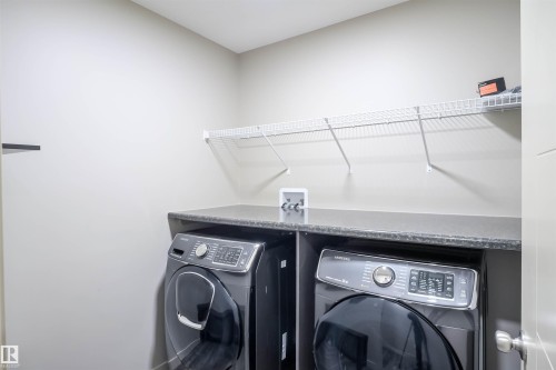 This room features light grey walls, grey wood-style flooring, and a window with curtains - 1426 25 Avenue, Edmonton, AB - Indoor Photo Showing Other Room