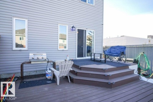 The property features a spacious deck with multi-level steps, an exterior light fixture, and sliding glass doors - 1426 25 Avenue, Edmonton, AB - Outdoor With Deck Patio Veranda With Exterior