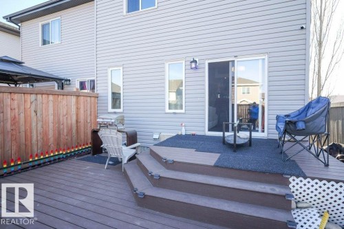 The property features a spacious deck with multi-level steps, a sliding glass door for access, and a wooden privacy fence - 1426 25 Avenue, Edmonton, AB - Outdoor With Deck Patio Veranda With Exterior