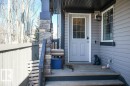 The property features an inviting front entrance with gray siding, a door with windowpanes, and a stone-clad pillar - 1426 25 Avenue, Edmonton, AB  - Outdoor With Exterior 